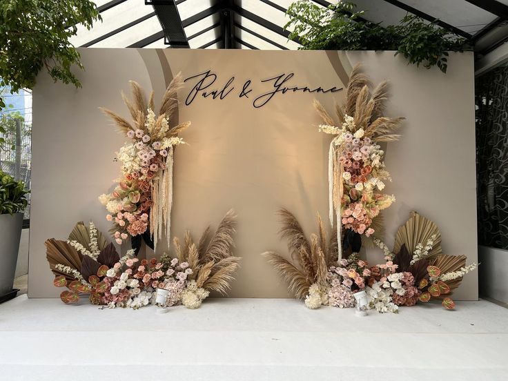 an image of a wedding backdrop with flowers and feathers