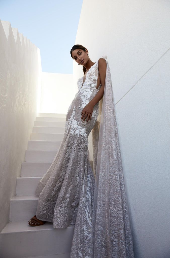 a woman is standing on some stairs wearing a dress