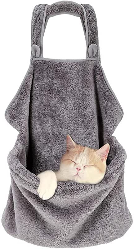 a cat sleeping in a pocket on top of a gray blanket with it's eyes closed