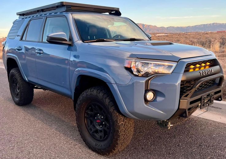 a blue truck parked on the side of a road