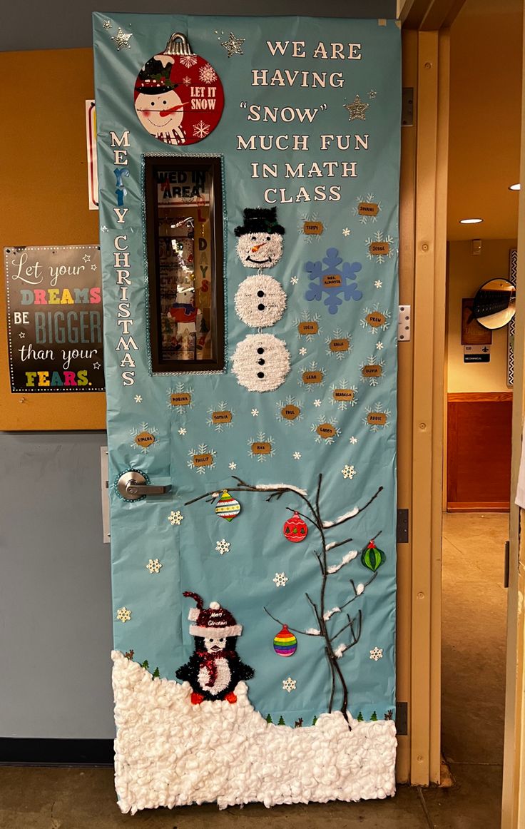 a door decorated with snowmen and other holiday decorations in front of a blue wall