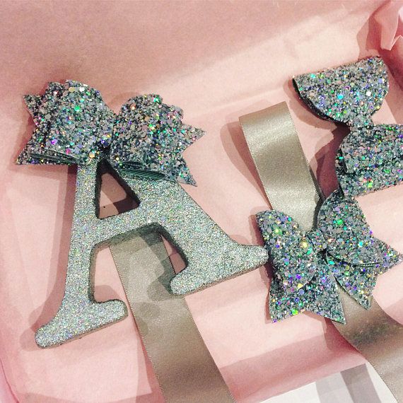 two glitter bow brooches sitting on top of a pink box