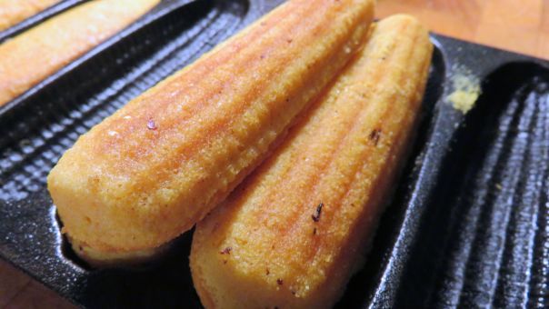 four fried food items in black trays on wooden table