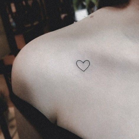 a woman with a small heart tattoo on her back