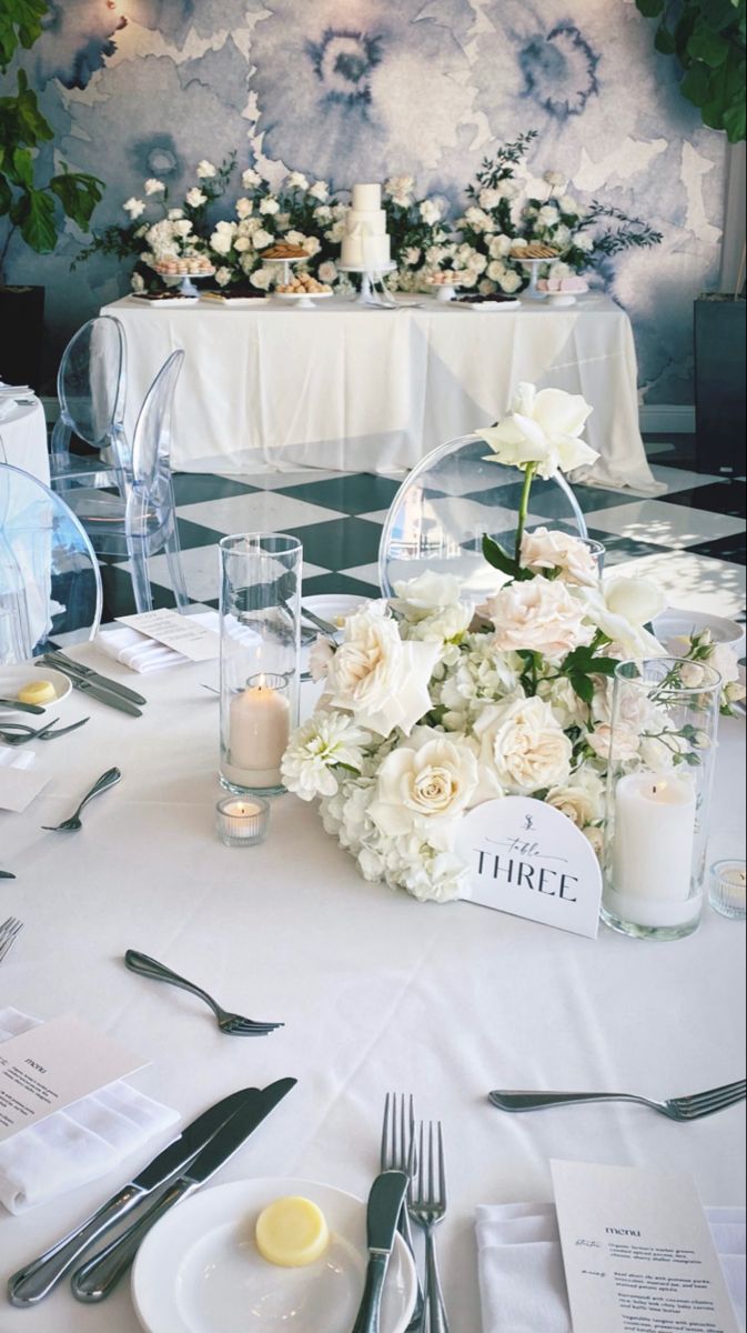 the table is set with white flowers and silverware for an elegant wedding breakfasteon