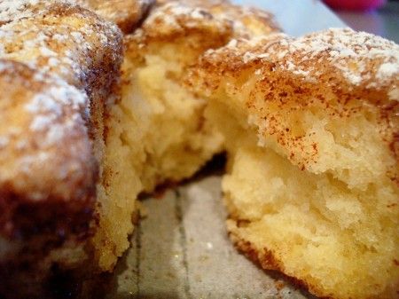 a donut that has been cut in half with powdered sugar on it and is sitting on a table