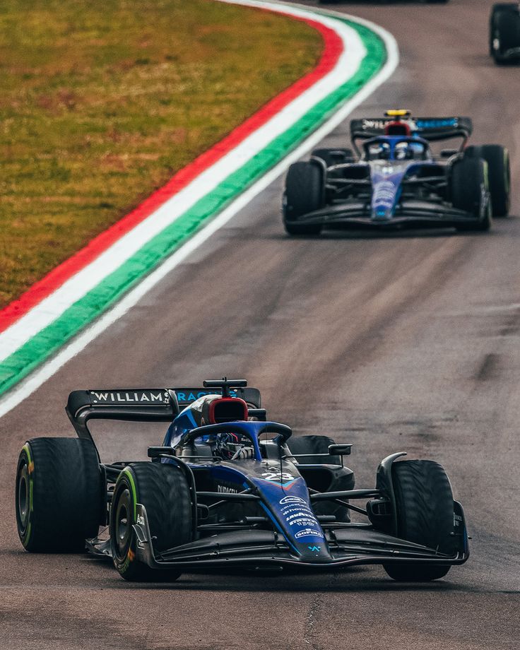 two racing cars driving on a race track