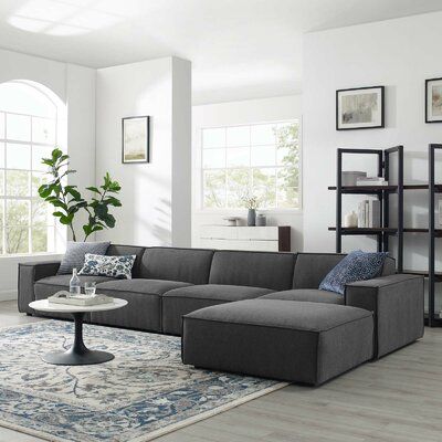 a living room filled with furniture and a large rug on top of a hard wood floor