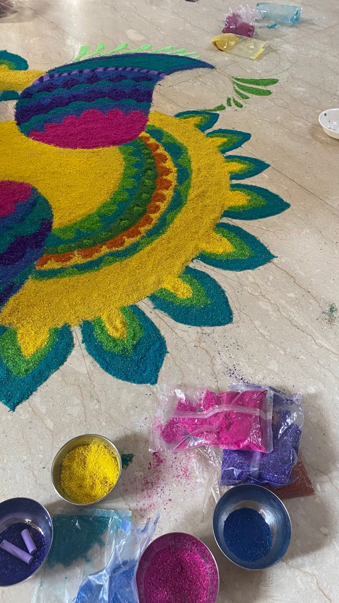 several bowls are sitting on the floor with colored powders in front of them and an image of a rooster