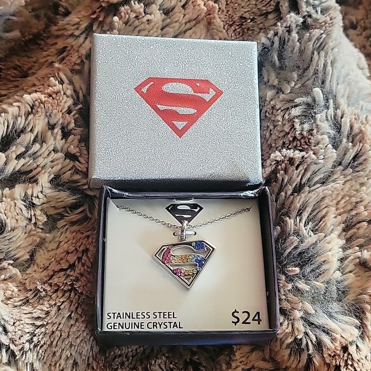 a box with a superman necklace in it