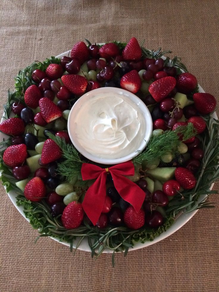 a platter with strawberries, grapes, and other fruit arranged in a wreath