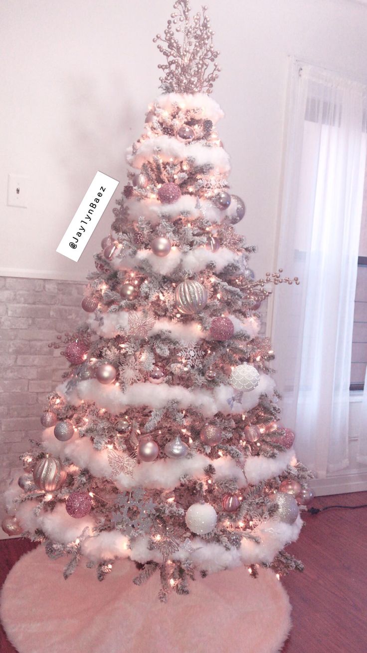 a white christmas tree with pink and silver ornaments