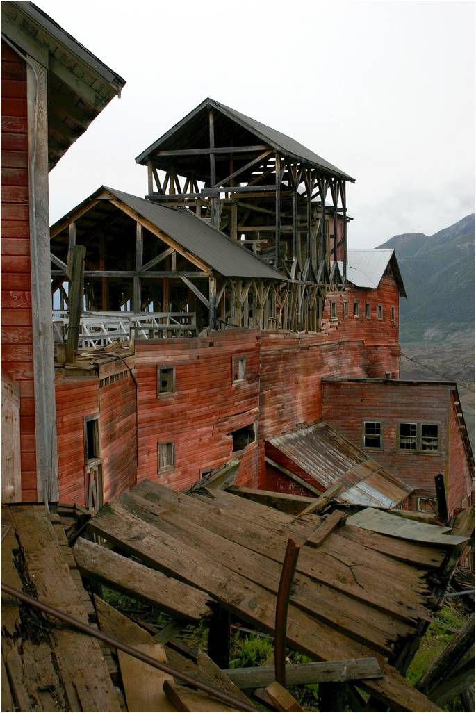 an old red brick building with wooden beams and roofing that has been torn down