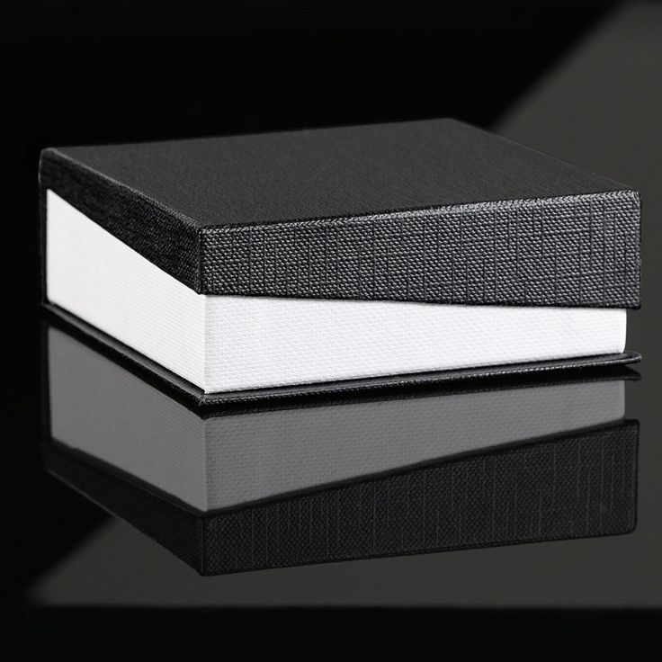 two black and white books sitting next to each other on top of a reflective surface