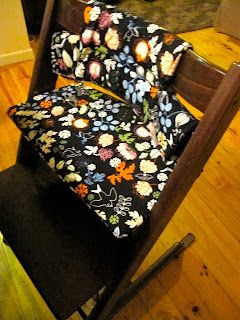 a chair with a flowered seat cover sitting on top of a hard wood floor