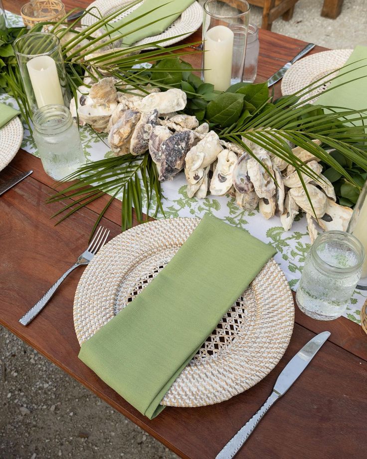 the table is set with plates, napkins and place settings for an outdoor dinner