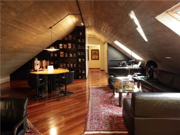 a living room filled with furniture next to a loft style wall mounted bookcases