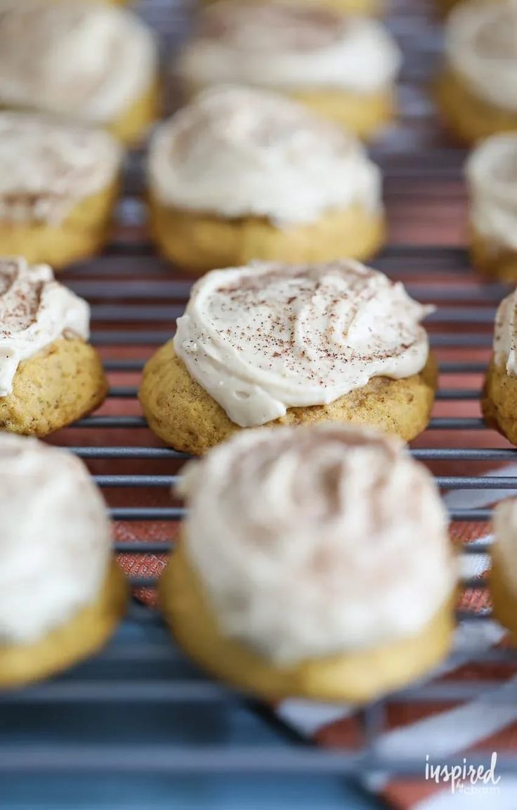 there are many cookies with frosting on the cooling rack