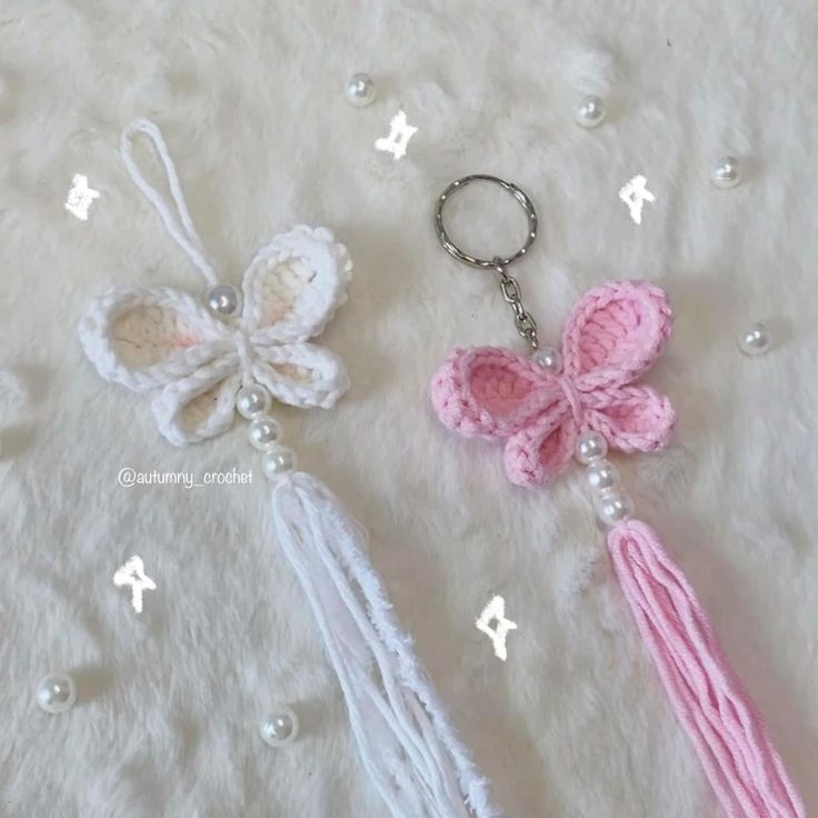 two crocheted keychains with tassels and beads on a white background