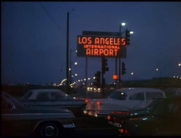 the los angeles international airport sign is lit up in the dark at night with traffic