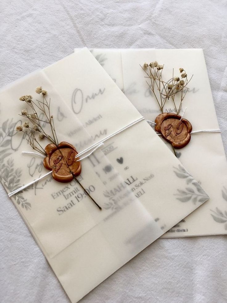 three envelopes with buttons and flowers on them