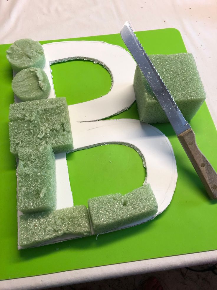 the cake is made to look like letter b and has green icing on it