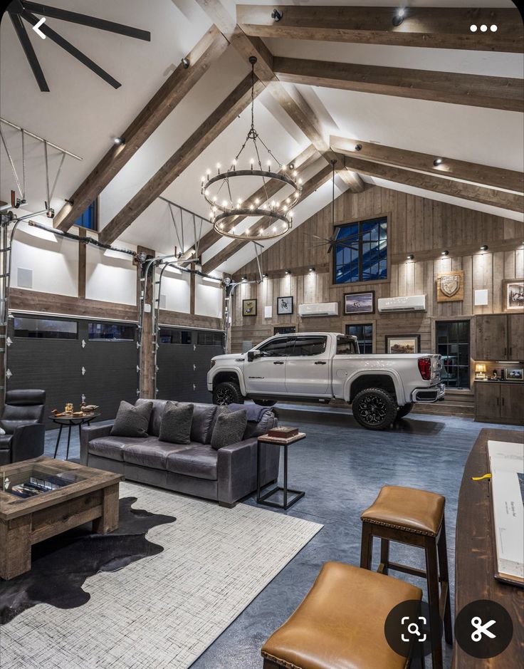 a living room with couches, tables and a truck parked in the garage behind it