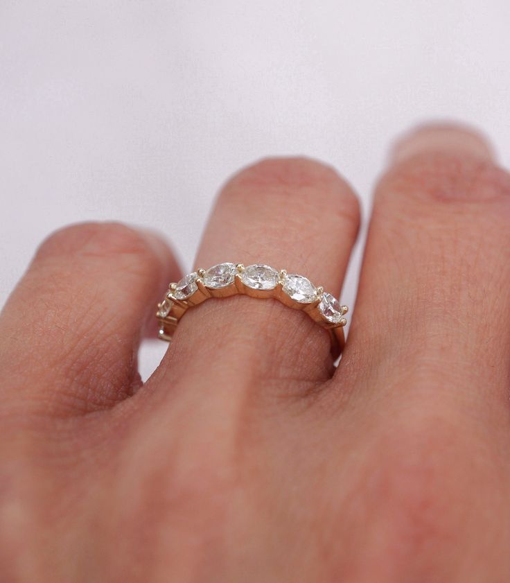 a woman's hand with a ring on it that has three stones in the middle