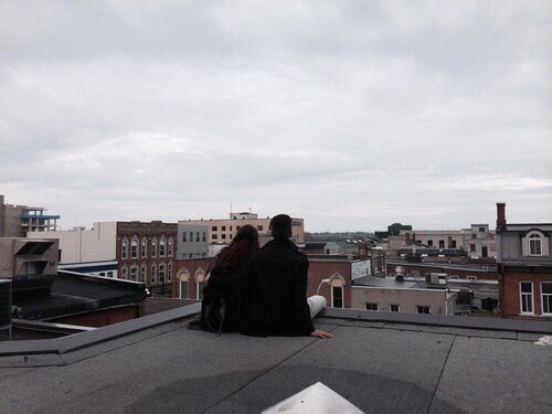 two people sitting on the roof of a building