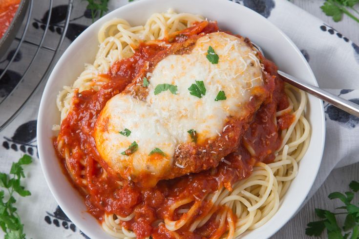 a bowl filled with spaghetti and meat covered in sauce