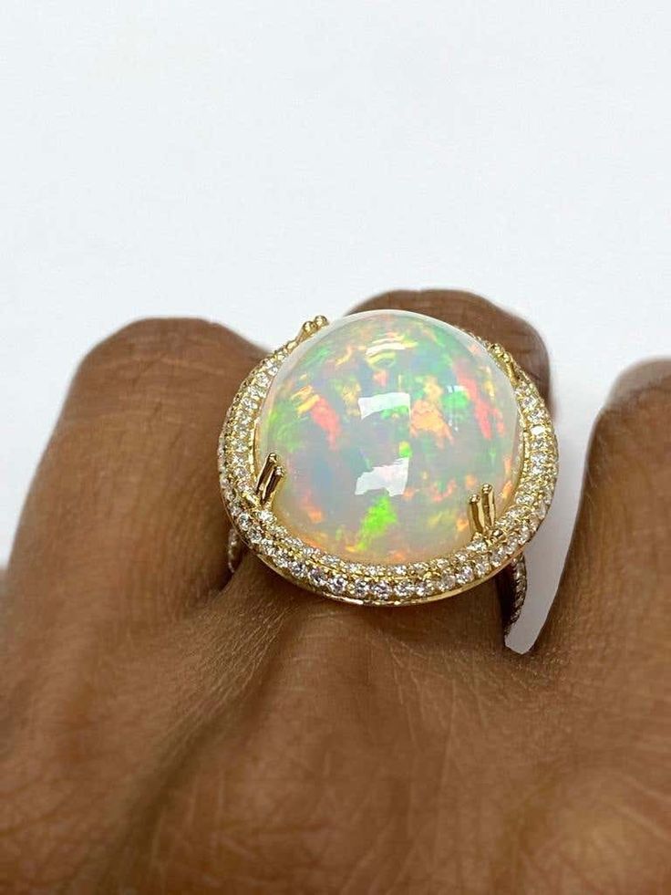 For Sale on 1stDibs - White Opal Cabochon Ring With Diamond in 18K Yellow Gold, from 'G-One' Collection Stone size: 24 X 19 mm Gemstone Weight: 19.20 Carat Diamonds G-H / VS Buying Gold, Ring With Diamond, Cabochon Ring, Gold Enamel, White Opal, Cocktail Rings, Ethiopian Opal, Diamond Ring, Gemstone Rings