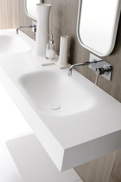 a bathroom sink with two mirrors above it and soap dispensers on the counter