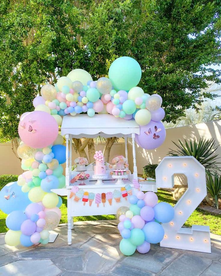 an outdoor birthday party with balloons and decorations