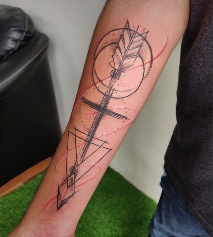 a man's arm with an arrow and compass tattoo on the left inner forearm