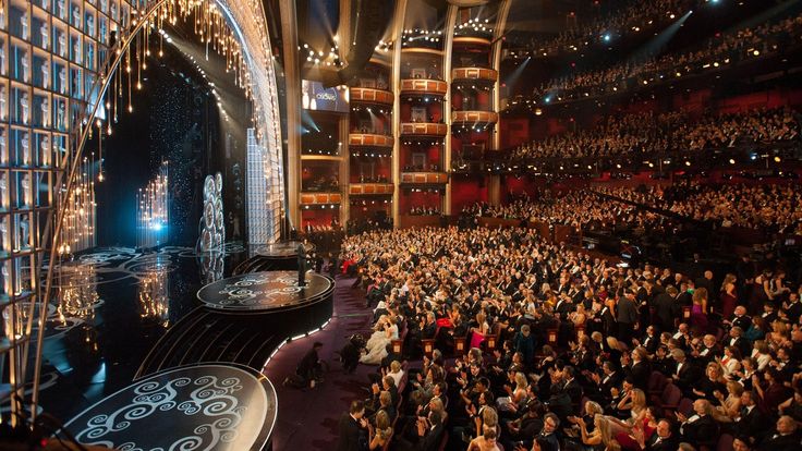 the stage is filled with people as they stand in front of an auditorium full of people