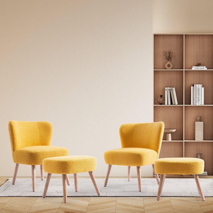 two yellow chairs sitting in front of a book shelf next to a chair and ottoman