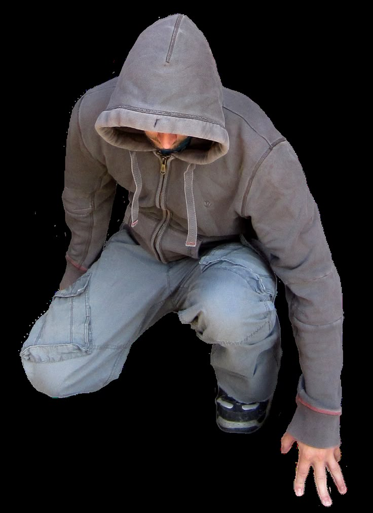 a man in grey hoodie and jeans crouching down