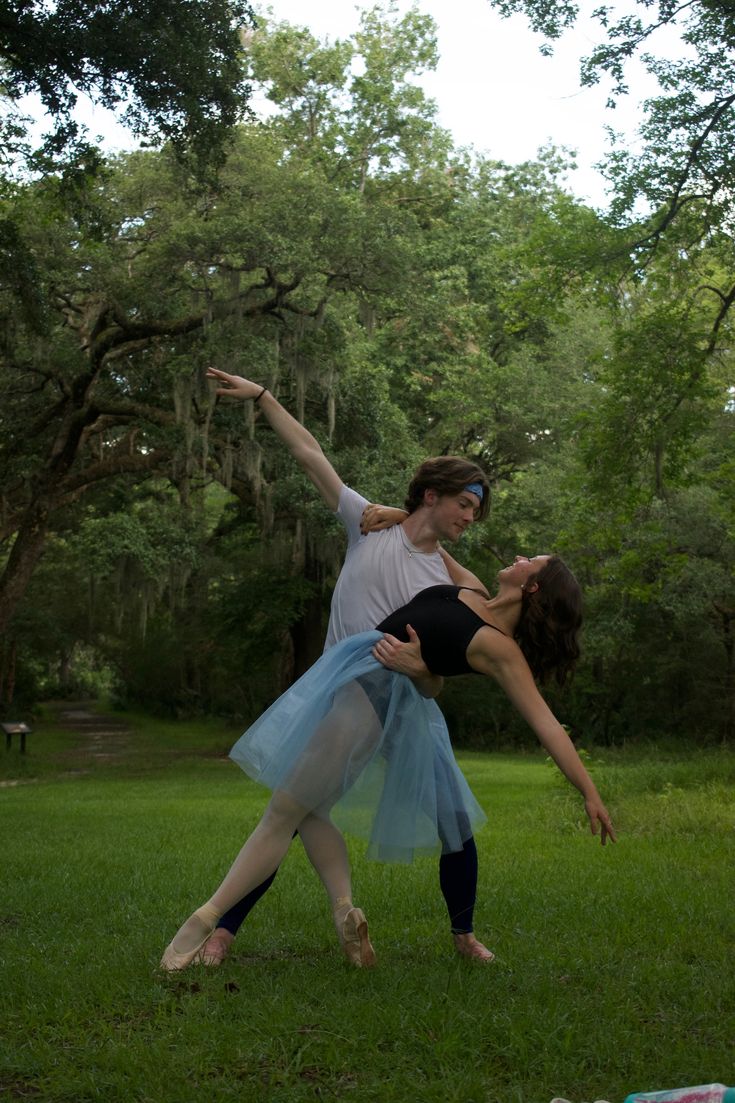 two people are dancing in the grass together