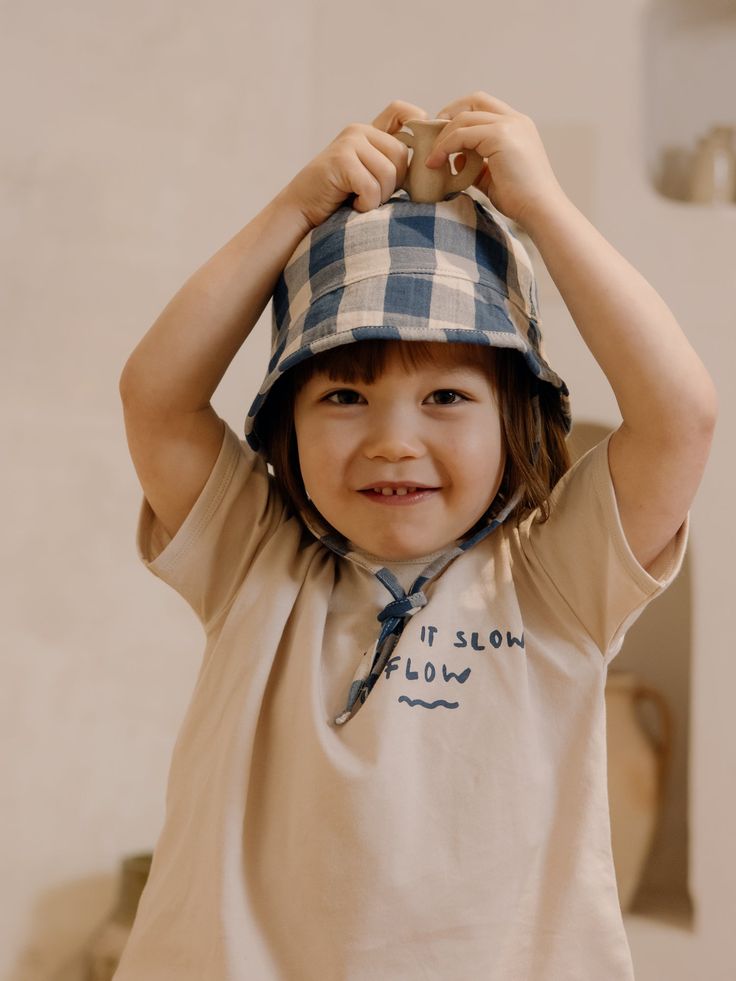 Our cute sun hats are meant for playful summer days filled with friends, laughter, and sunshine! 100% organic muslin cotton, 130g This hat is our favourite this season. In a classic shape featuring our NEW chunky gingham pattern, it is perfect for all the pool adventures or splashing in the sea. Add a pair of sandals, and your baby is ready to play in the sand for hours! Wear it with our matching gingham pieces for a coordinated look, or mix and match for playful outfits. Designed in the UK. Mad Playful Cotton Sun Hat For Vacation, Spring Bucket Hat With Curved Brim, Playful Cotton Sun Hat With Wide Brim, Playful Cotton Bucket Hat For Vacation, Playtime Cotton Bucket Hat With Wide Brim, Cotton Hats With Uv Protection, Playful Cotton Sun Hat For The Beach, Playful Cotton Hats With Uv Protection, Cotton Curved Brim Sun Hat For Playtime