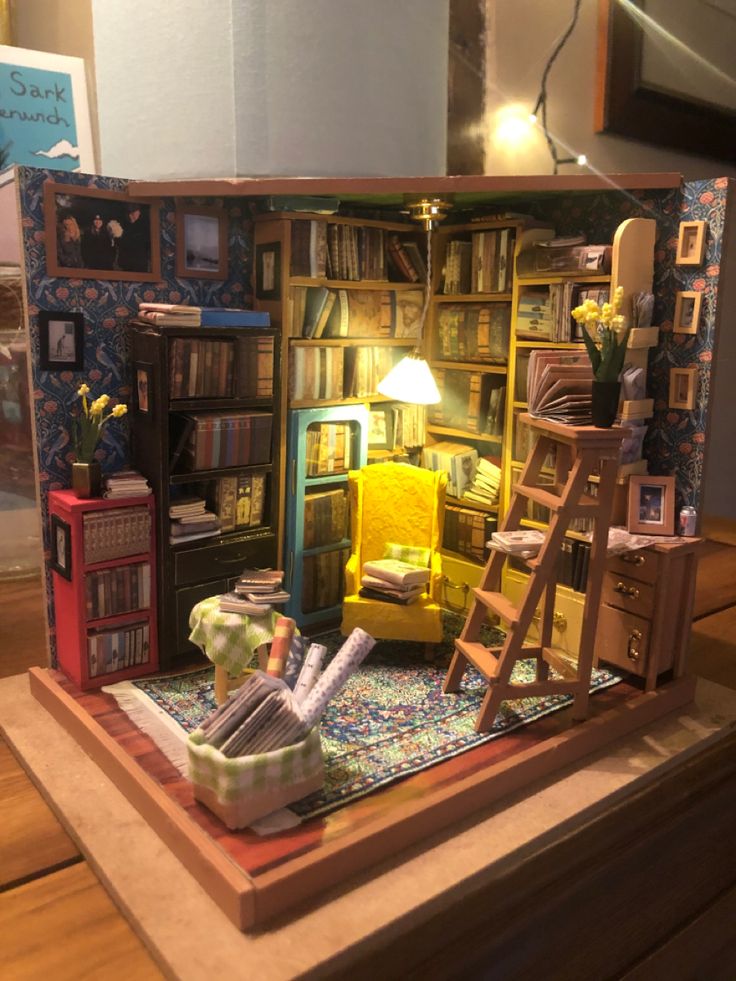 a doll house with bookshelves, ladders and furniture in the middle of it