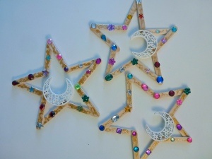 three star and moon decorations made out of popsicle sticks with beaded stars on them