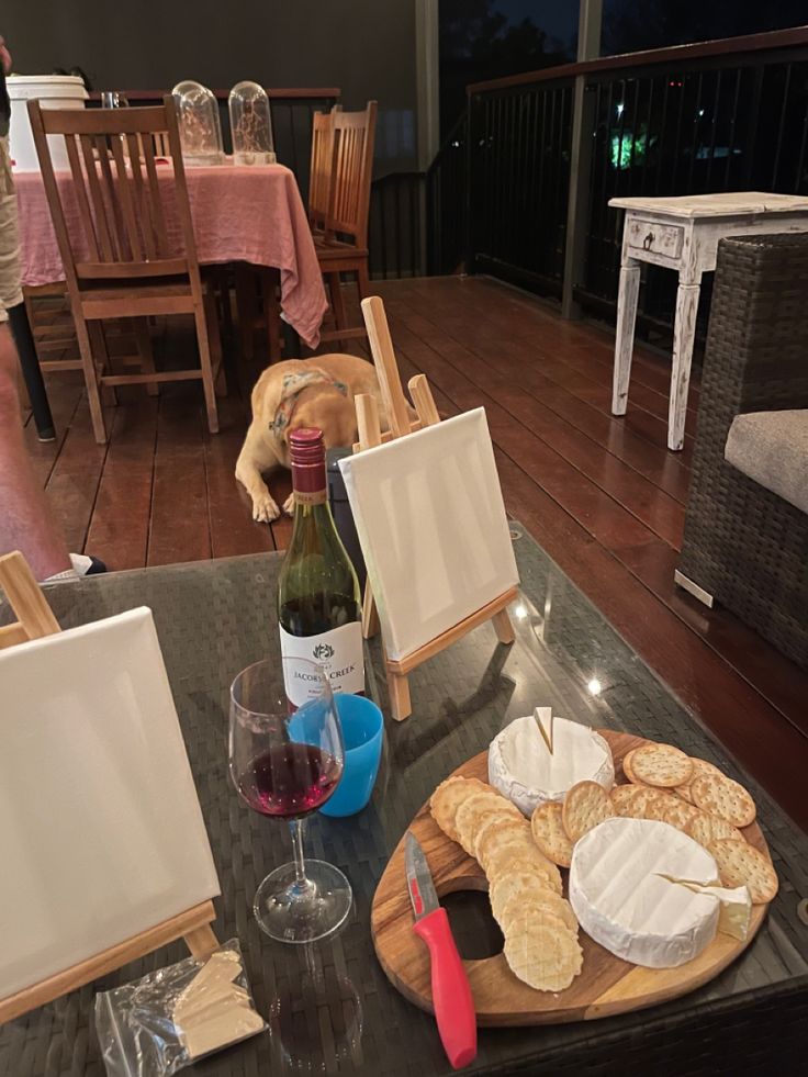 a table with wine, cheese and crackers on it