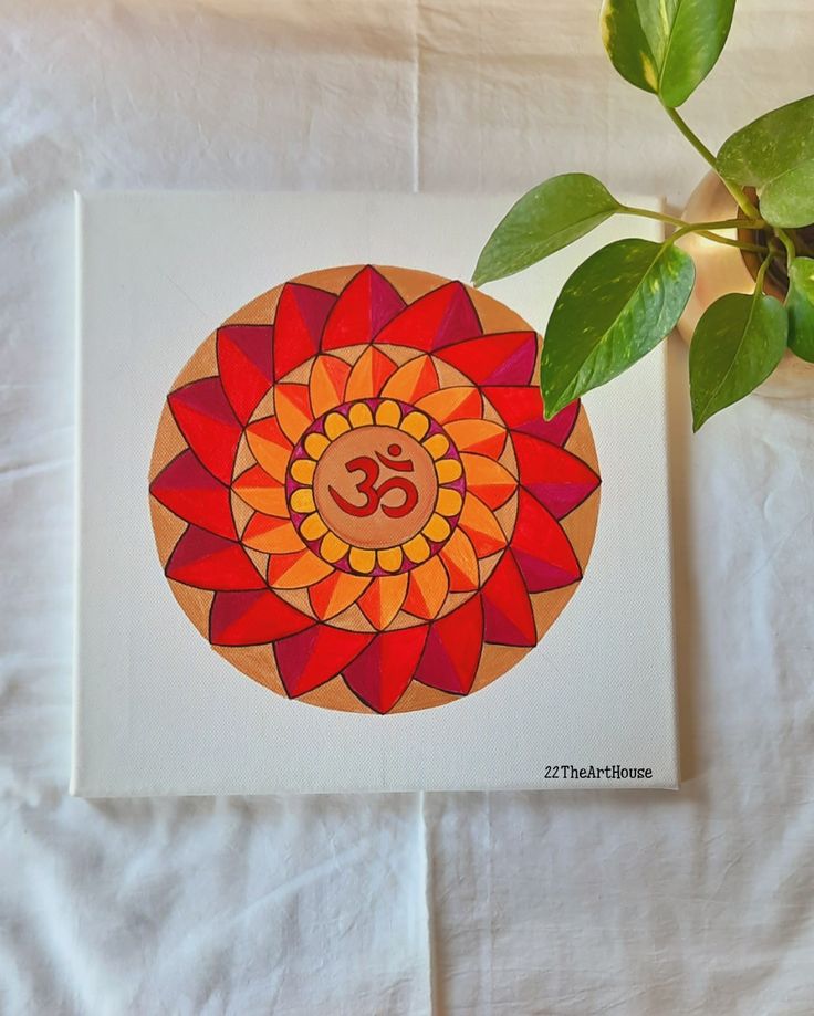 a red and orange flower sitting on top of a white sheet next to a green plant