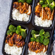 four trays filled with chicken, broccoli and rice