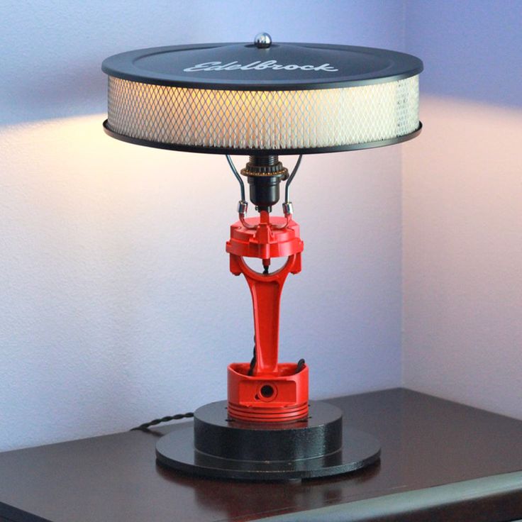 a red lamp sitting on top of a wooden table