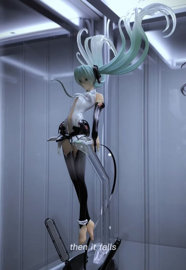 there is a figurine that looks like a girl with green hair and black pants