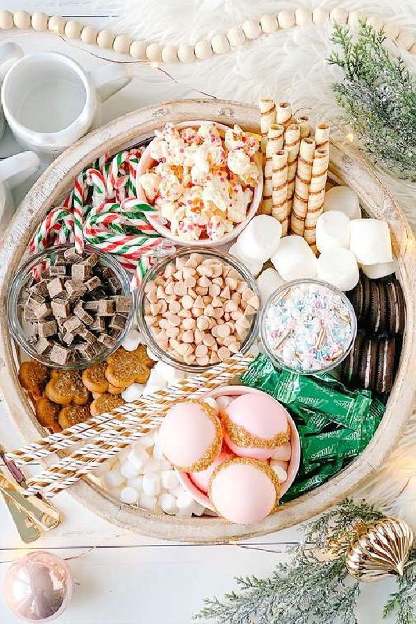 a platter filled with cookies, marshmallows, and other holiday treats