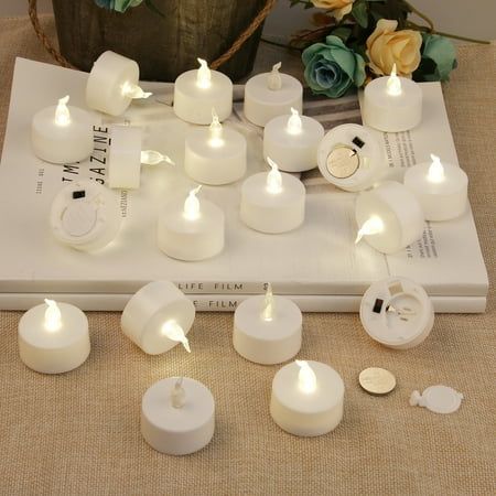 several white candles sitting on top of a book