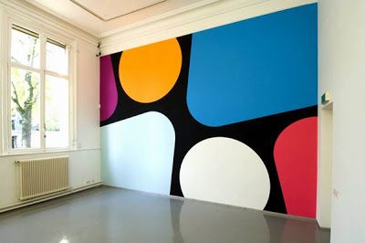 an empty room with a large colorful painting on the wall and a radiator