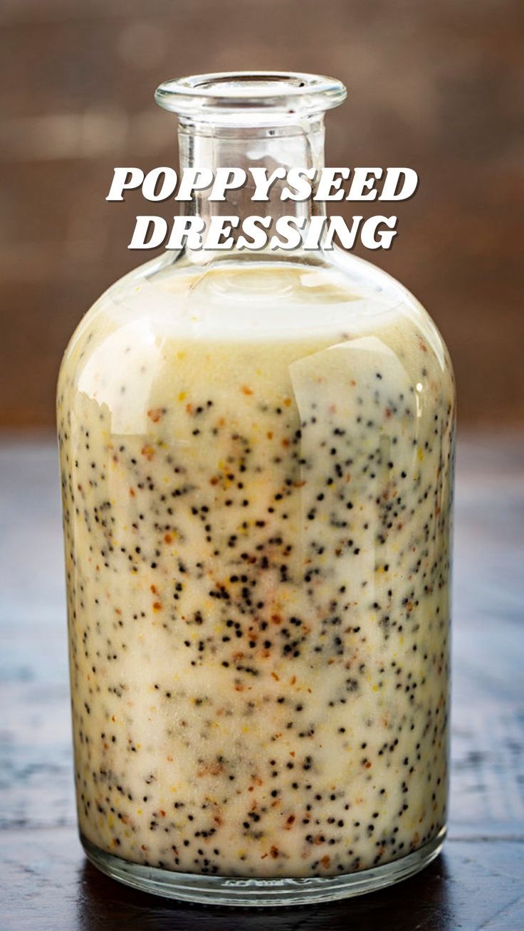 poppy seed dressing in a glass jar on a wooden table with the words poppy seed dressing above it